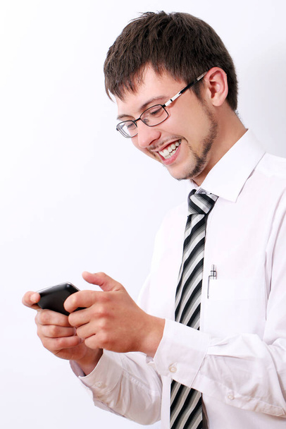 Young and happy businessman typing sms on his cellphone - Foto, Imagen