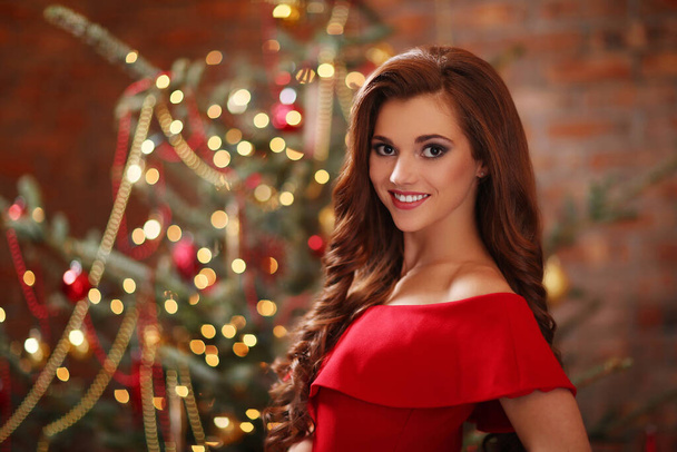 No Natal. Mulher de vestido vermelho perto da árvore de Natal - Foto, Imagem