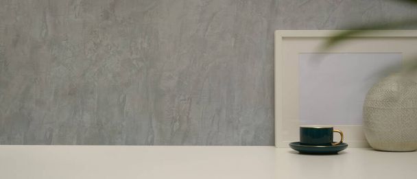 Vista ravvicinata del moderno design degli interni domestici con spazio copia, modello di telaio, vaso e tazza sulla scrivania con parete soppalco - Foto, immagini