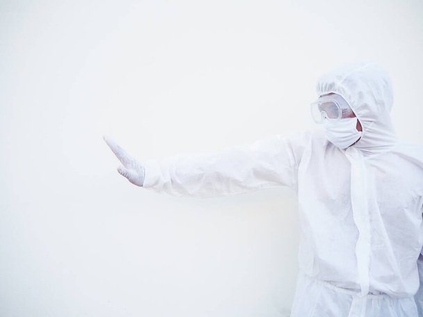 Aziatische arts of wetenschapper in PPE suite uniform toont stopbord met zijn armen om te stoppen met iets te doen terwijl hij vooruit kijkt. gebaren stoppen, waarschuwen voor gevaar. Coronavirus of COVID-19 concept geïsoleerde witte achtergrond - Foto, afbeelding