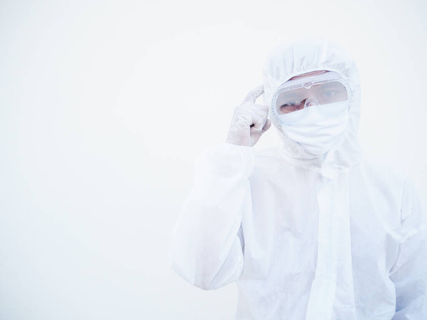 Ázsiai férfi orvos vagy tudós PPE lakosztály egyenruhában mutatja ujjal mutogatva az agyra, miközben áll, és várja a másolás helyet szöveg vagy design. coronavirus vagy COVID-19 koncepció izolált fehér háttér - Fotó, kép