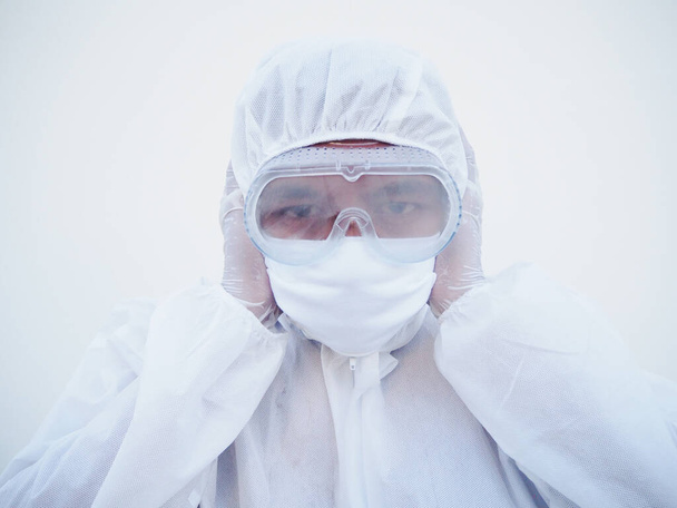 PPE üniformalı Asyalı doktor ya da bilim adamı kulakları elleriyle kapatıyor. Koronavirüs tehlikesi veya COVID-19 konsepti izole edilmiş beyaz arkaplan - Fotoğraf, Görsel