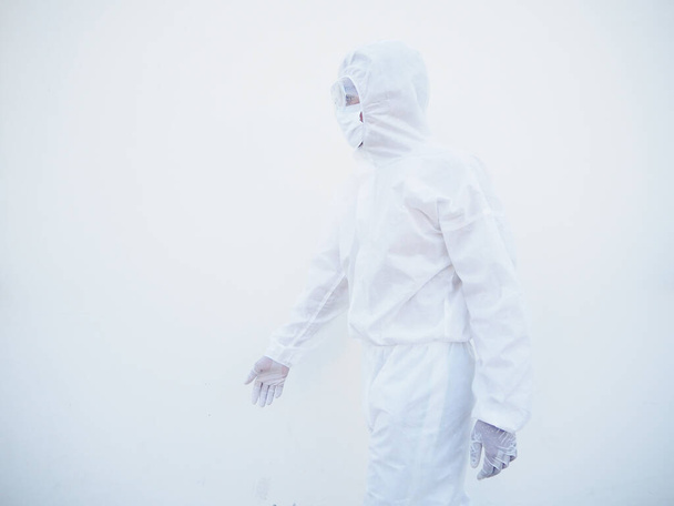 Vue de côté médecin ou scientifique en uniforme PPE suite debout avec comme marcher vers l'avant. coronavirus ou COVID-19 fond blanc isolé - Photo, image