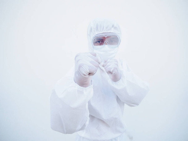 Lekarz lub naukowiec w mundurze PPE suite stojący z podniesionymi pięściami jak bokser do walki z koronawirusem lub COVID-19 z wybiegającym do przodu odizolowanym białym tłem - Zdjęcie, obraz