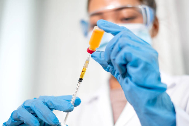 A hivatásos orvosok vírusfertőzések elleni védőoltás és -kezelés céljából vizsgálják és elemzik a vakcinák mintáit. Egészségügyi és egészségügyi koncepciók. - Fotó, kép