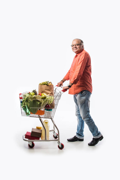 Viejo indio con carrito de compras o carrito lleno de verduras, frutas y comestibles - Foto, Imagen
