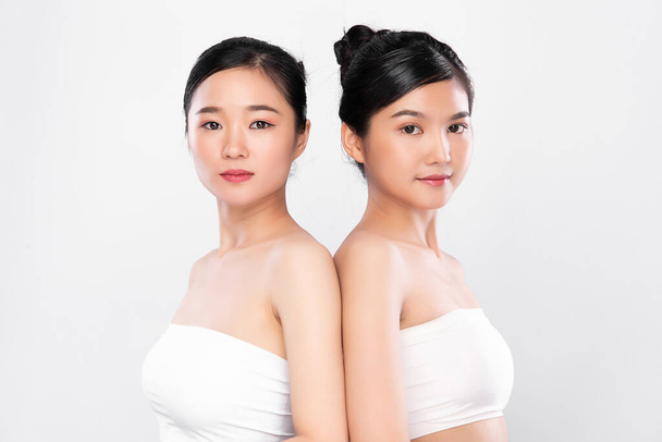 きれいな新鮮な肌を持つ2つの美しい若いアジアの女性,白い背景に,顔のケア,顔の治療.美容、美容、スパ。アジア女性の肖像画 - 写真・画像