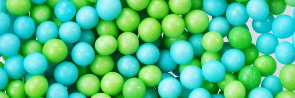 Green and blue eatable sugar pearls for food decoration. Panoramic image - 写真・画像