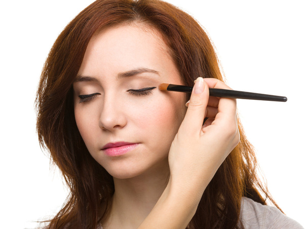 Stylist is applying eyeshadow for young girl - Photo, Image