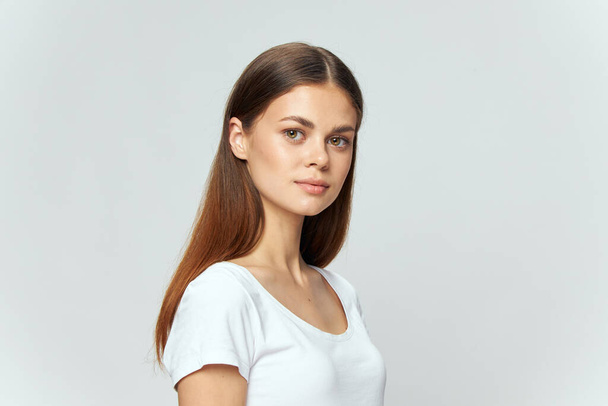 Retrato de una hermosa mujer en una camiseta blanca sonrisa morena  - Foto, Imagen