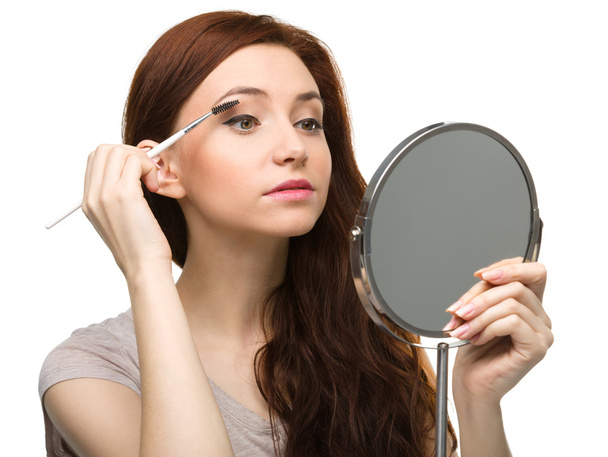 Young woman is applying eyeshadow - Photo, Image