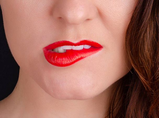Girl bites her lip close-up - Фото, изображение