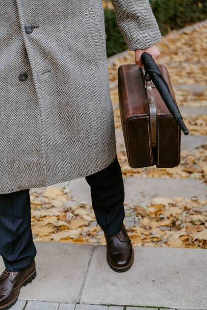 Men's autumn fashion. Man in stylish shoes and a white coat - Foto, Imagen