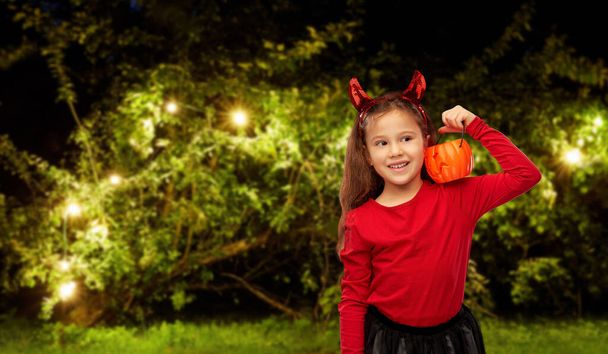 girl in halloween costume with jack-o-lantern - 写真・画像