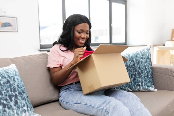 african american woman opening parcel box at home - Foto, afbeelding