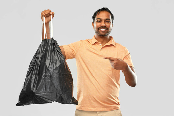 smiling indian man holding trash bag - Photo, image