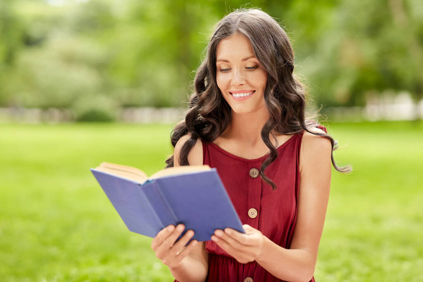 happy smiling woman reading book at park - Foto, Imagem