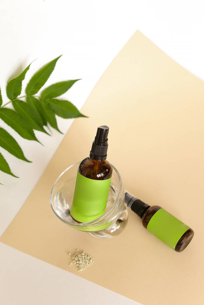 Zaměřte se na láhev i sklo s kosmetickým výrobkem a zelený prostor pro značku v blízkosti listu. - Fotografie, Obrázek