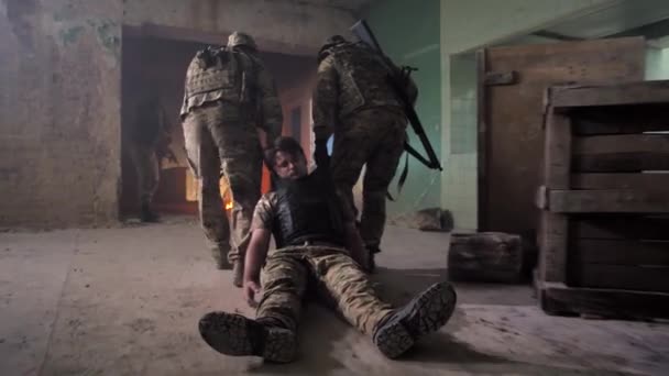 Στρατιώτες σέρνουν τραυματίες μακριά από το πεδίο της μάχης - Πλάνα, βίντεο