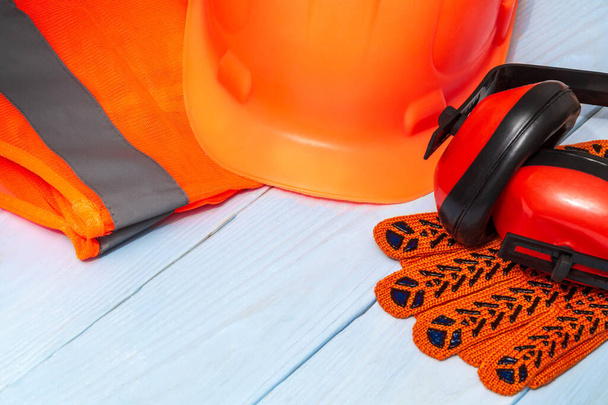 Maître constructeur équipement de protection orange empilés sur des planches bleues avant le travail - Photo, image