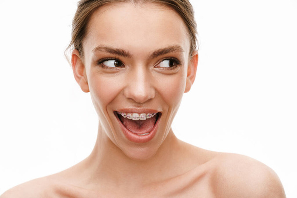 Image of beautiful caucasian young shirtless woman wearing braces smiling isolated over white background - Foto, immagini