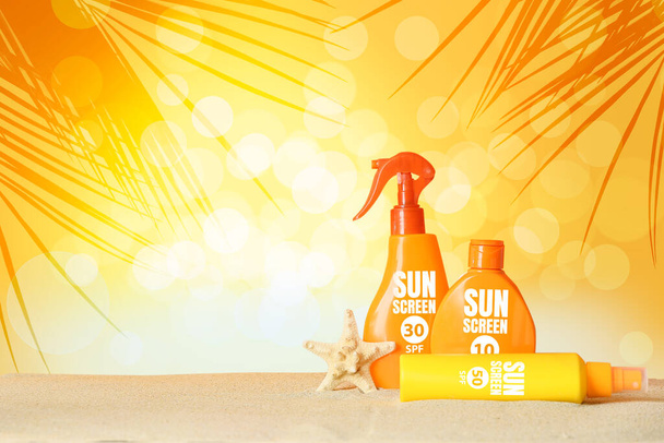 Bottles of sunscreen cream on beach sand at resort - Zdjęcie, obraz