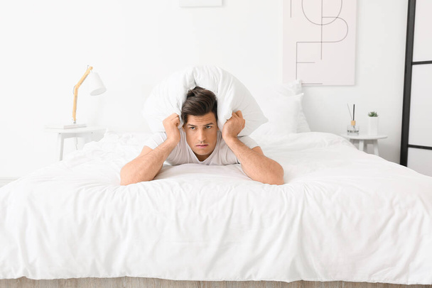 Young man suffering from insomnia in bedroom - Fotografie, Obrázek