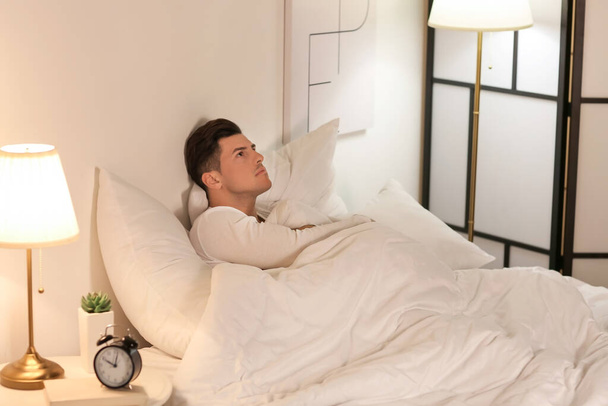 Young man suffering from insomnia in bedroom - Photo, Image