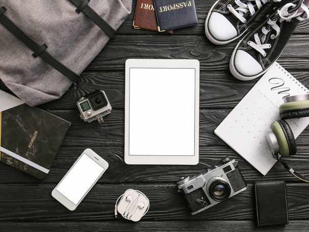 Composition with tablet computer and travel accessories on wooden background - Fotoğraf, Görsel