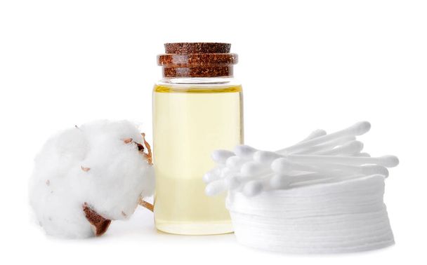 Flasche Baumwollsamenöl mit Kosmetikkissen und Sticks auf weißem Hintergrund - Foto, Bild