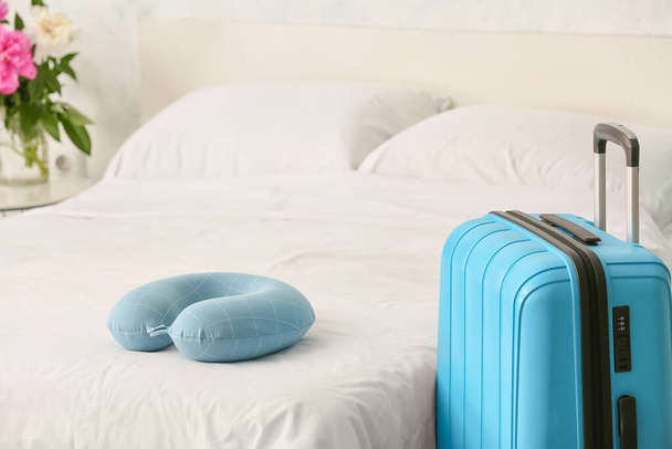 Подушка для путешествий и чемодан в спальне - Фото, изображение