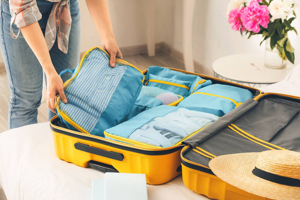 Mujer empacando ropa antes del viaje en casa - Foto, imagen