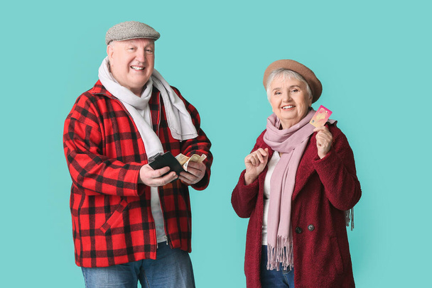 Happy senior couple with money on color background - Фото, изображение