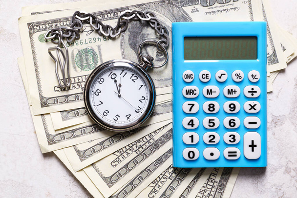 Zakhorloge met rekenmachine en geld op lichte achtergrond - Foto, afbeelding