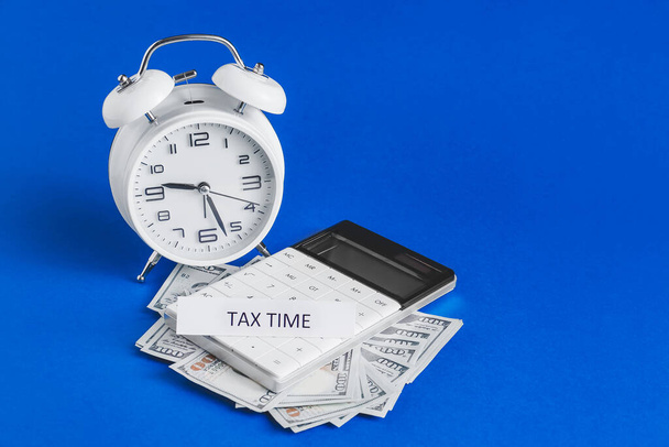 Relógio despertador com calculadora e dinheiro sobre fundo de cor. Conceito de prazo fiscal - Foto, Imagem