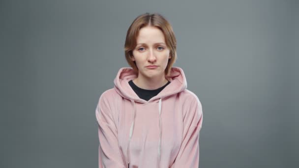 Video mladé smutné ženy v růžové mikině - Záběry, video