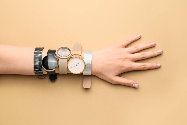 Kobieta ręka ze stylowymi zegarkami na nadgarstku na tle koloru - Zdjęcie, obraz