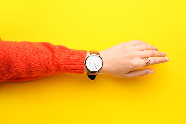 Kobieta ręka ze stylowym zegarkiem na nadgarstku na tle koloru - Zdjęcie, obraz