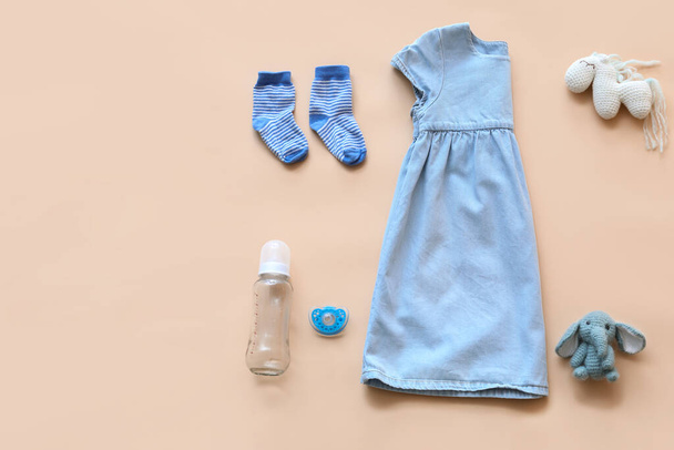 Baby clothes with bottle, pacifier and toys on color background - Photo, Image