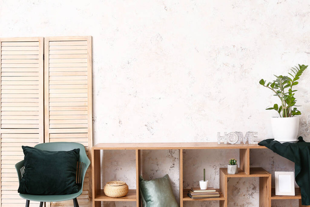 Dřevěný stojan s výzdobou u světelné stěny v pokoji - Fotografie, Obrázek