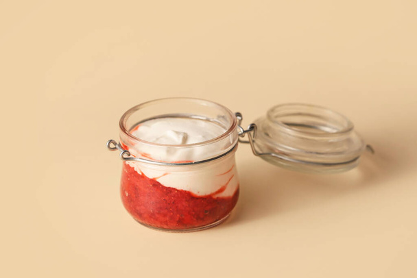 Jar of strawberry yogurt on color background - Φωτογραφία, εικόνα