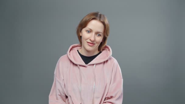 Video of young grimacing woman in pink sweatshirt - Footage, Video