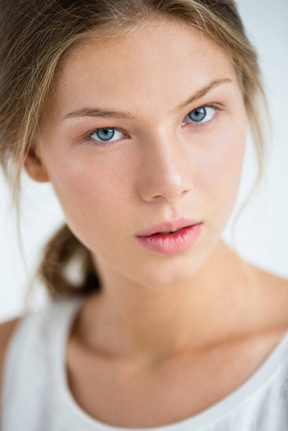  woman without makeup, beautiful pleasant face, blonde hair pulled back, selective focus, head rests on knees - Foto, Bild