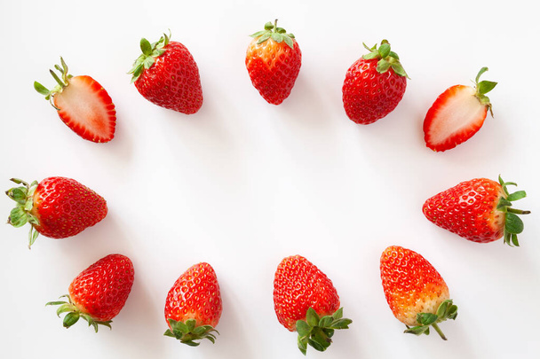 Oval frame of whole and halved strawberries on white background. Isolated. Copy space. - Fotoğraf, Görsel
