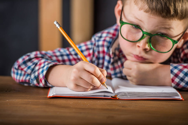 Niño de la escuela concentrándose en su trabajo escolar - Foto, imagen