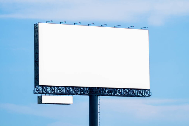 Blank makieta billboard z białym ekranem przed chmurami i niebieskim tle nieba. Kopiuj kosmiczny baner reklamowy - Zdjęcie, obraz