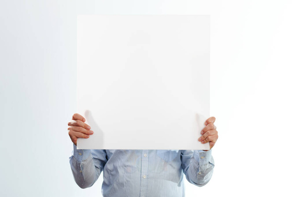 Mann im Hemd zeigt weißes Banner auf Studiohintergrund - Foto, Bild