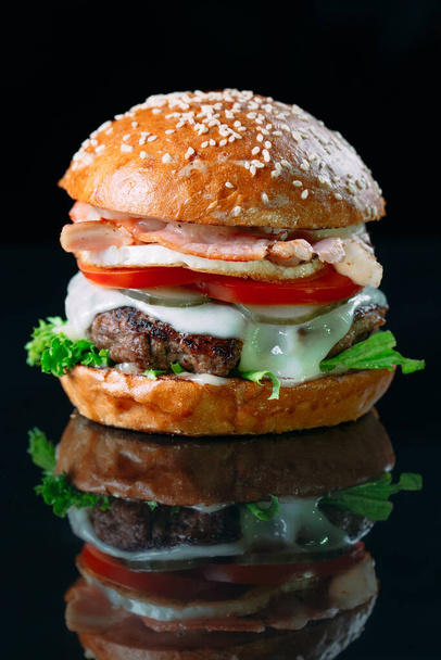 Juicy beef Burger on a black background. - Φωτογραφία, εικόνα