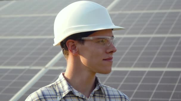 Engineer in a white helmet is at the solar power station - Imágenes, Vídeo