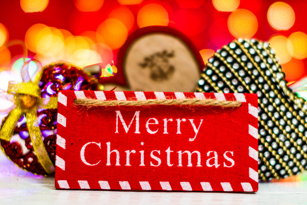 Boldog karácsonyt szöveg fa jel, dekorációk és díszek egy színes karácsonyi kompozíció. - Fotó, kép